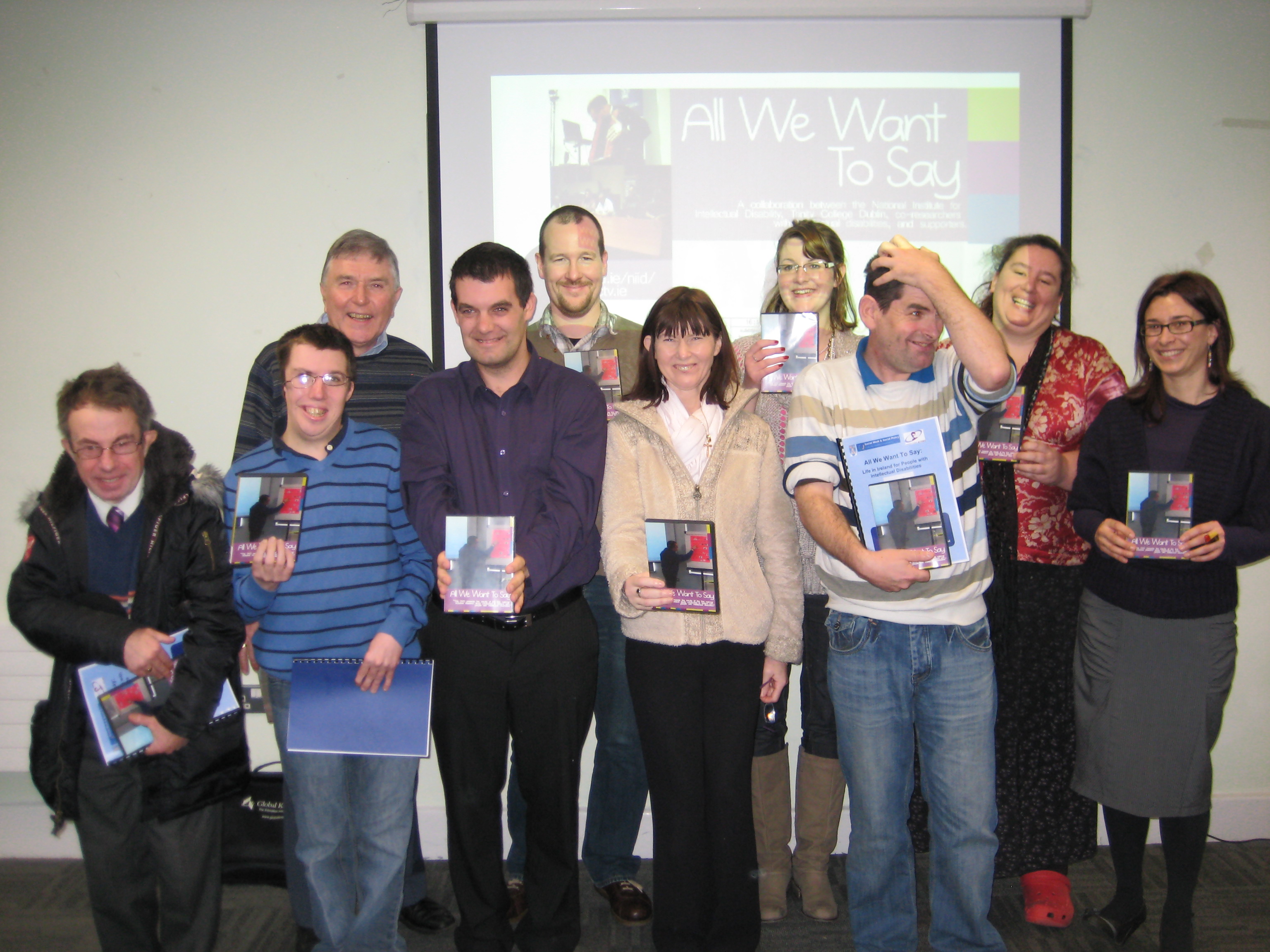 Members of the All We Want to Say Project have a group photo at the NIID, Trinity College. They are holding All We Want to Say Study Reports and the DVDs.